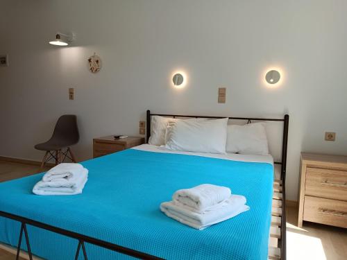 ein Schlafzimmer mit einem blauen Bett und Handtüchern darauf in der Unterkunft Imeros in Chania