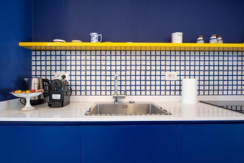um balcão de cozinha com um lavatório e uma parede azul em Il sorriso di Bri em Capri