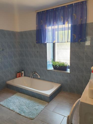 a bath tub in a bathroom with a window at Eni's Villa, 5km From Shengjini Beach in Lezhë