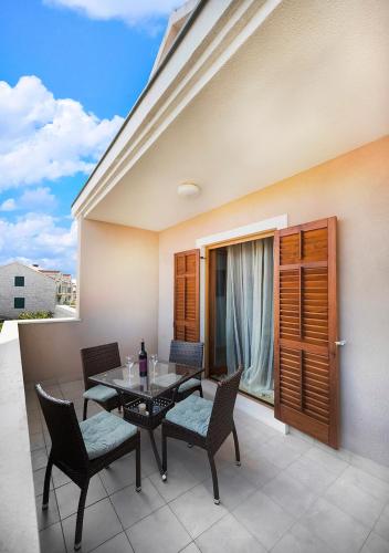 a patio with a table and chairs on a balcony at Apartment Zen u Postira in Postira