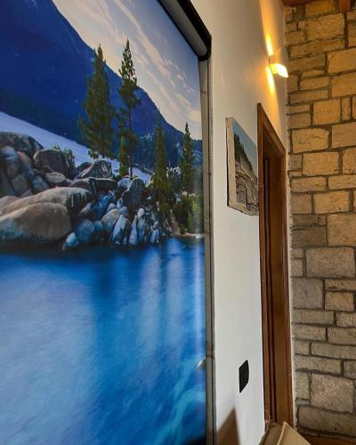 a painting of a river on the side of a wall at Palermiti Luxury Rooms in Himare