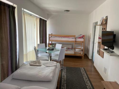 ein kleines Zimmer mit einem Bett und einem Tisch sowie einem Schlafzimmer. in der Unterkunft Aprtments Belma in Sarajevo
