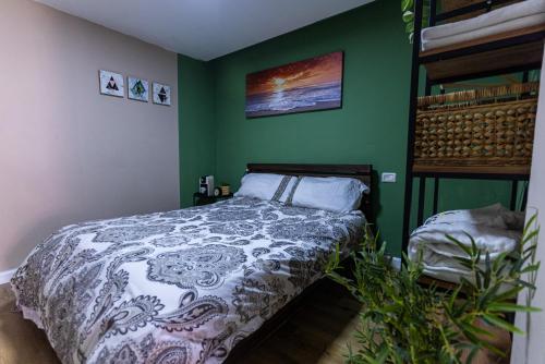 a bedroom with a bed and a green wall at פאטה מורגנה אואזיס - בית נופש פרטי in Beer Sheva