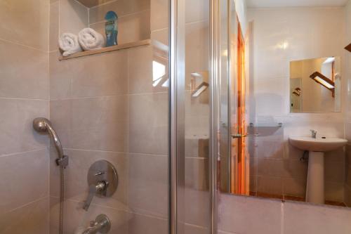 a bathroom with a glass shower and a sink at Korsan Apartment No.16 in Kaş