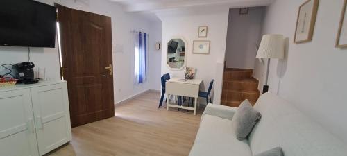 a living room with a white couch and a table at Geranio Chipionahome in Chipiona