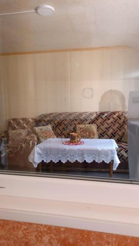 a table in a display window with a couch at Arman Guest House in Dilijan