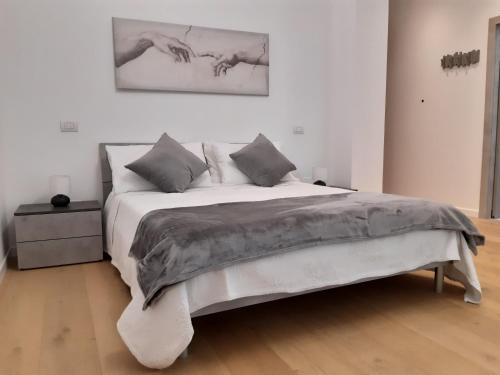 una camera da letto con un grande letto in una stanza bianca di Piazza Mazzini Apartment a Lecce