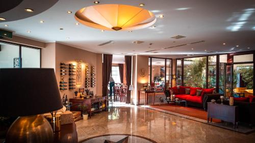 a lobby with a red couch and a room with windows at Hotel Tihany Átrium in Tihany