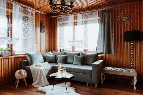 een woonkamer met een bank en een tafel bij Tatra House in Poronin