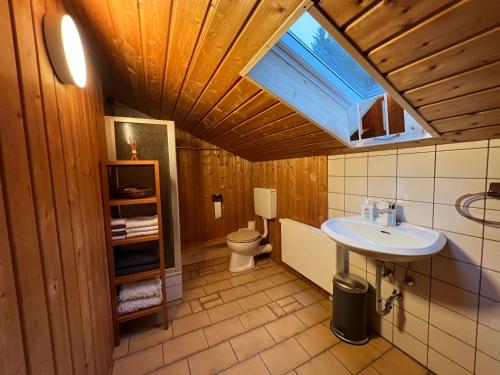 ein Bad mit einem Waschbecken, einem WC und einem Fenster in der Unterkunft Grimmersberg in Oberkirch