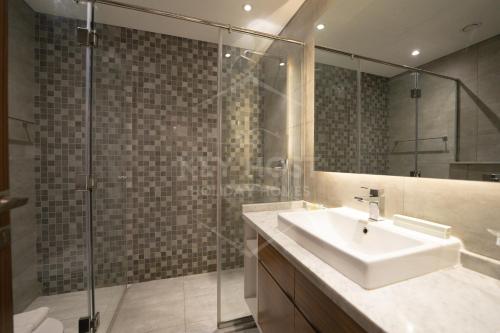 a bathroom with a sink and a glass shower at KeyHost - Regent Court JVC - KG20 in Dubai