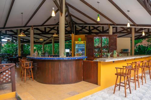 a bar in a restaurant with wooden tables and chairs at Aninga Lodge in Tortuguero