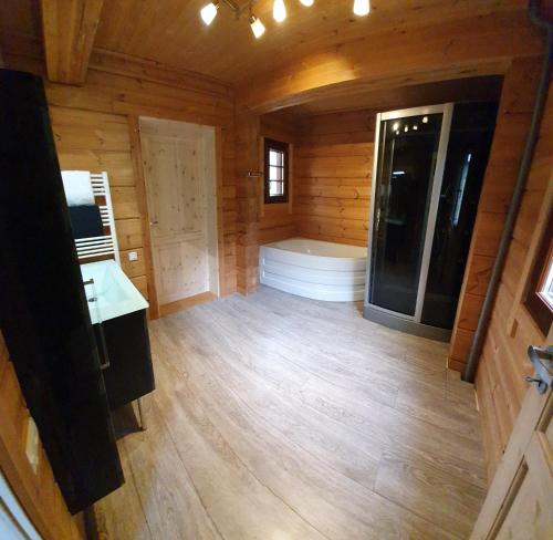 an empty room with a tub in a wooden cabin at Chalet Etoile in Abondance