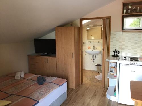 a bedroom with a bed and a sink in a room at Drávecz Apartman in Balatonlelle