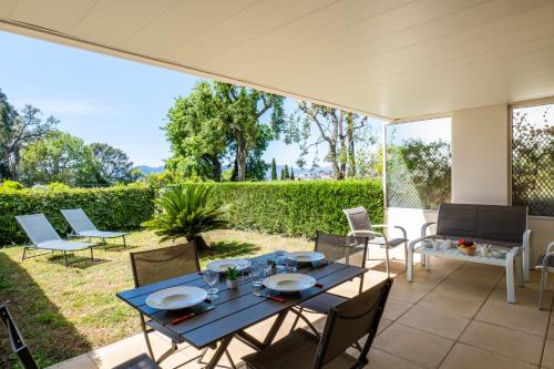 patio z niebieskim stołem i krzesłami w obiekcie Garden-Level Apartment Pool & Sea View w Cannes