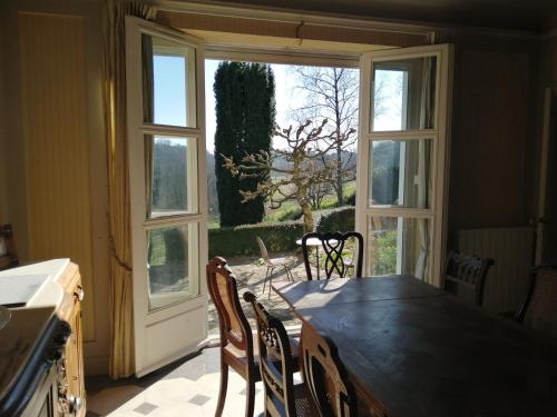 een keuken met een tafel en stoelen en een raam bij Villa Biscondau in Oloron-Sainte-Marie