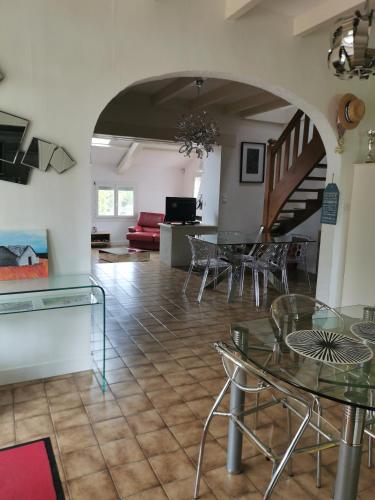 - un salon avec des tables et des chaises et un escalier dans l'établissement Hébergement, à Montpezat-de-Quercy