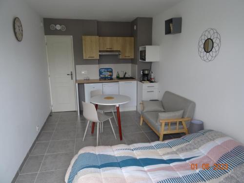 une chambre avec un lit et une table et une cuisine dans l'établissement Studio climatisé à 10 min de la plage, à Villers-sur-Mer