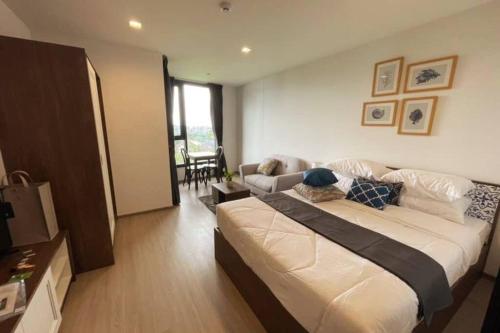 1 dormitorio con 1 cama grande y sala de estar en Elevated Elegance 7th Floor Cozy Flat with WiFi, en Ban Rangeng
