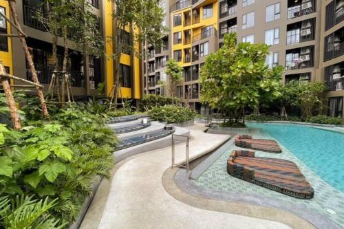 a courtyard with a swimming pool and some buildings at The Base Central - Luxury Resort-Style Comfort in Ban Rangeng