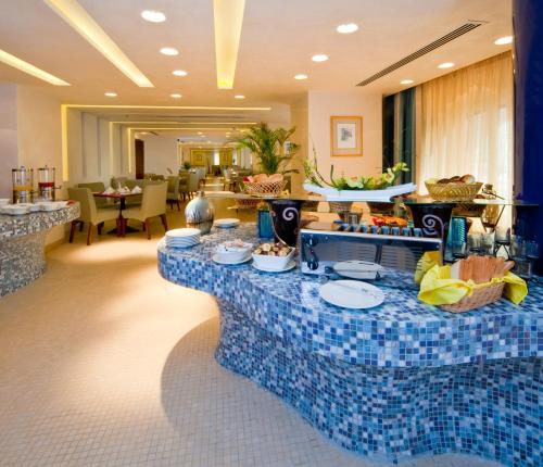 a lobby with a table with food on it at City Seasons Al Hamra Hotel in Abu Dhabi