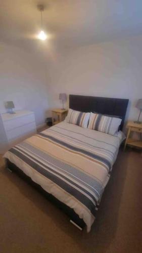 リミントンにあるSpacious self contained flat in superb locationのナイトスタンド2台付きの部屋のベッド1台