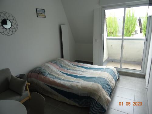 une petite chambre avec un lit et une fenêtre dans l'établissement Studio climatisé à 10 min de la plage, à Villers-sur-Mer