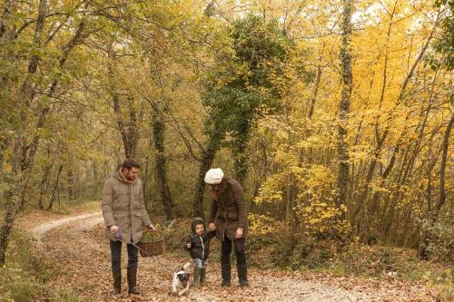 two adults and a child and a dog on a trail at Il Borro Relais & Châteaux in San Giustino Valdarno