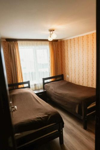 a bedroom with two beds and a window at Arsenas Guest House in Kazbegi