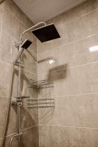a shower with a glass door in a bathroom at Arsenas Guest House in Kazbegi