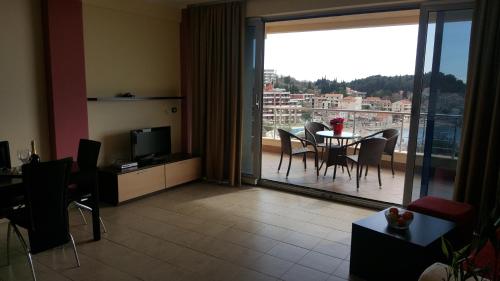 ein Wohnzimmer mit einem Tisch und Stühlen sowie einem Balkon in der Unterkunft Apartments Rino Lux in Sveti Stefan