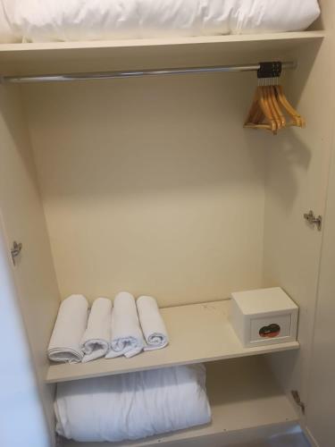 a shelf with towels and a box in a room at SUMMER OTEL in Muğla