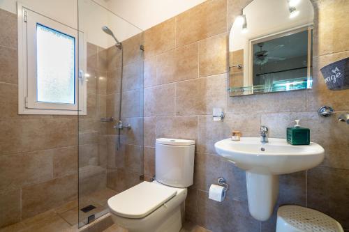 e bagno con servizi igienici, lavandino e doccia. di Villa Millianna - Ground Floor Apt a Cefalonia
