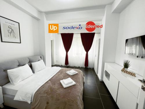 a small bedroom with a bed and a tv at Cozy Aparthotel - Central City Suceava in Suceava