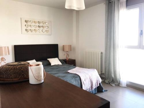 a bedroom with a bed and a table in it at New Apartment 800m from the beach + pool + garage in Calafell