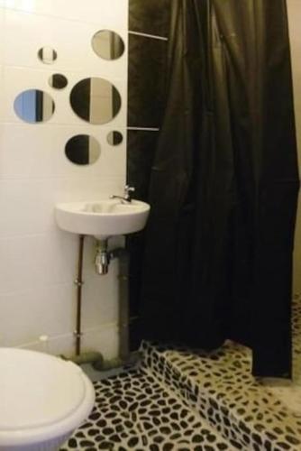 La salle de bains est pourvue d'un rideau de douche noir et de toilettes. dans l'établissement Nid douillet pour 2.. à 50 mètres de la plage, à Mers-les-Bains