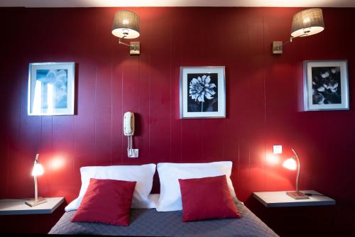 a bedroom with red walls and a bed with red pillows at Hotel La Chope in Cambrai