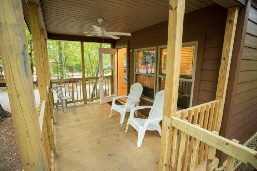 a porch with white chairs and a ceiling fan at Lake George Escape in Warrensburg