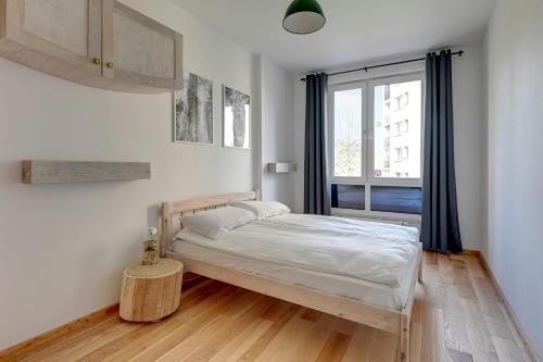 a small bedroom with a bed and a window at Staywin WILCZA apartments in Gdańsk