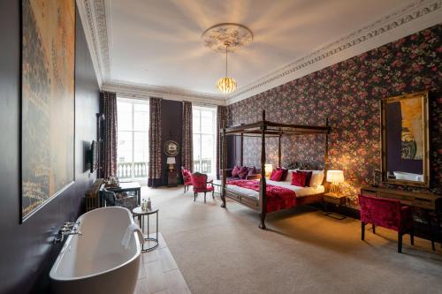 a bedroom with a bed and a tub in a room at No11 Boutique Hotel & Brasserie in Edinburgh