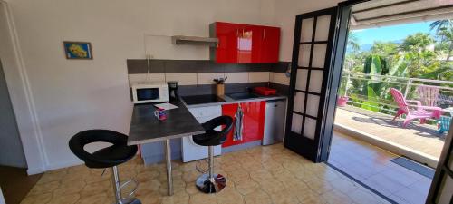 a kitchen with a counter with chairs and a balcony at ESCAL RUN in Le Tampon
