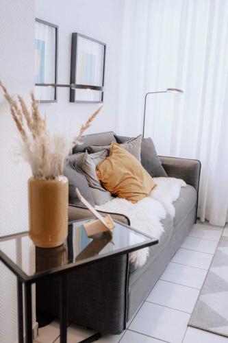 a living room with a couch and a glass table at Haus Sandröschen in Norderney