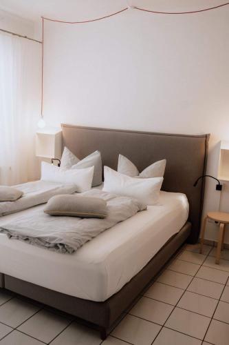 a bed with white pillows on it in a room at Haus Sandröschen in Norderney