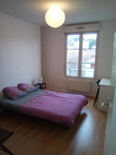 - une chambre avec un lit violet dans une pièce dotée d'une fenêtre dans l'établissement Tréfilerie, à Saint-Étienne