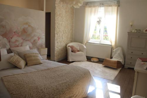 um quarto com uma cama, uma cadeira e uma janela em Chambre d'hôtes Les Magnolias em Pontpierre