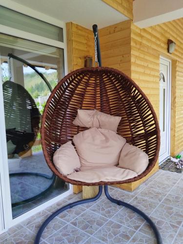 a wicker chair sitting on a porch at Stari Hrast 2 in Prolomska Banja
