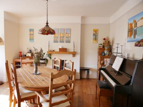 a dining room with a table and a piano at Close to beaches and town, off street parking in Kent