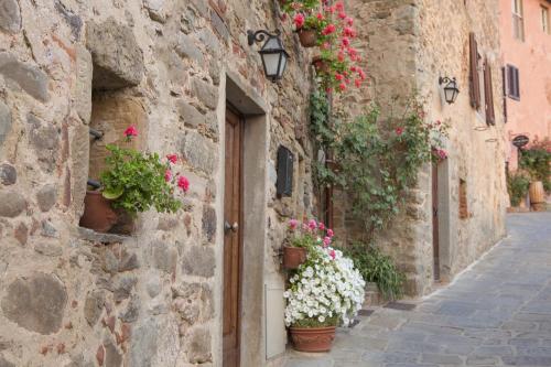 a stone building with flowers on the side of a street at Il Borro Relais & Châteaux in San Giustino Valdarno