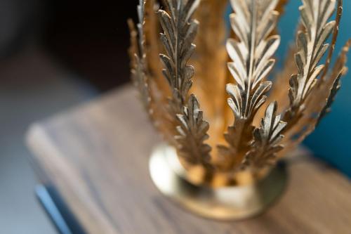 a metal vase with a plant on a table at No11 Boutique Hotel & Brasserie in Edinburgh