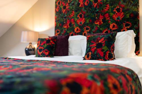 a bedroom with a bed with pillows and a floral wall at No11 Boutique Hotel & Brasserie in Edinburgh